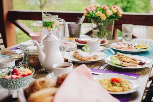 a wooden table with plates of breakfast food on it at Hotel Stein Elbogen in Loket