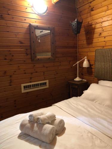 a bedroom with a bed with two towels on it at Cabin Resort in Moshav Ramot