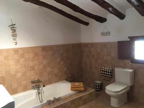 a bathroom with a tub and a toilet at Cortijo Esquina B&B Guesthouse in Arboleas