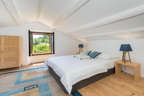 a white bedroom with a bed and a window at Villa Paula in Sveta Marina