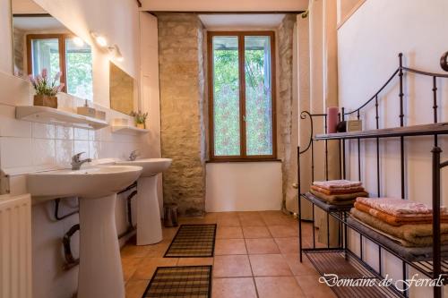een badkamer met een wastafel, een spiegel en een trap bij Cosy a la campagne in Solsac