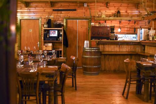 a restaurant with tables and chairs and a wine barrel at Cabin Resort in Moshav Ramot