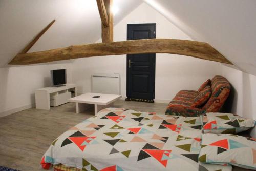 - une chambre avec un lit doté d'une poutre en bois au-dessus dans l'établissement Gîte de la Grange, à Ruillé-en-Champagne