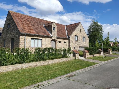 a brick house with a red roof on a street at MOLO house - cosy house with sunny garden and bbq in silent surroundings - near the BEACH - ideal for families and quiet groups - 15 km from BRUGES in Blankenberge