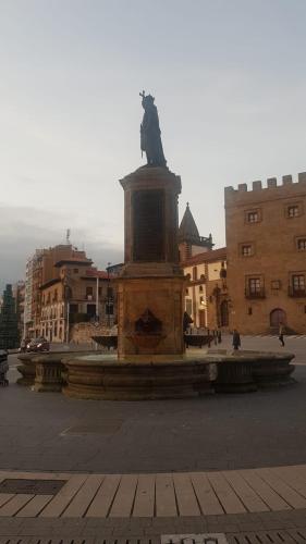a statue in the middle of a city with buildings at 1930 Diecinueve Treinta "Diseño, historia y confort en el centro de Gijón" in Gijón