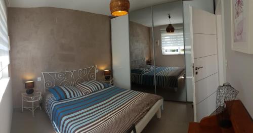 1 Schlafzimmer mit 2 Betten und einem Spiegel in der Unterkunft A l'Ancien Moulin in Lampertheim