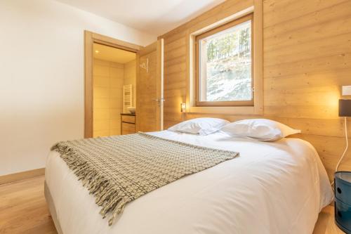 a bedroom with a white bed with a window at LE RIDGE Appartement Premium - Les Arcs Paradiski in Arc 1600