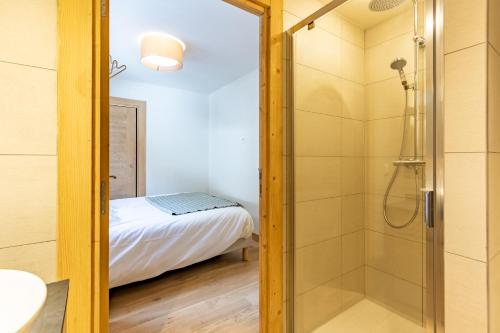 a bathroom with a shower and a bed at LE RIDGE Résidence Premium - Les Arcs Paradiski in Arc 1600