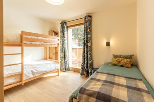 a bedroom with a bunk bed and a window at LE RIDGE Appartement Premium - Les Arcs Paradiski in Arc 1600