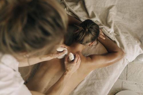 a woman laying on a bed brushing her teeth at Naturhotel Leitlhof in San Candido