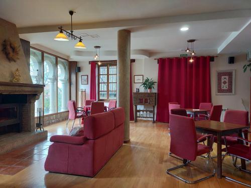 a living room with red chairs and a fireplace at Antiguas Eras La Alberca in La Alberca