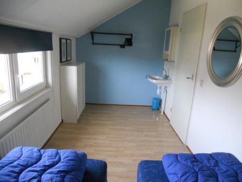 a living room with a blue couch and a sink at Vakantiehuis Grevelingen 12 aan Grevelingenmeer. nabij Port Greve in Brouwershaven
