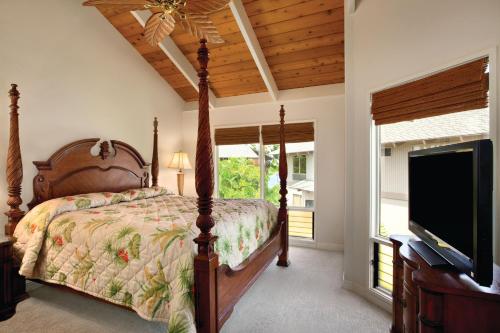 a bedroom with a bed and a flat screen tv at Castle Kanaloa at Kona in Kailua-Kona