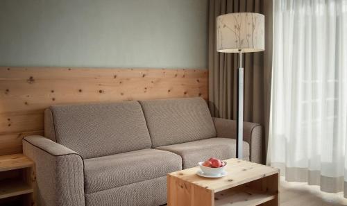 a living room with a couch and a table at Naturhotel Leitlhof in San Candido