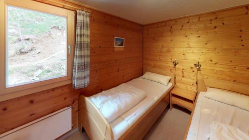 a small room with a bed and a window at Danica in Blatten bei Naters