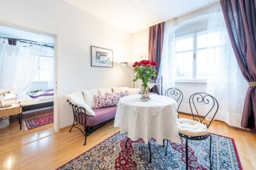a living room with a table with a vase of flowers on it at Schlosshotel Rosenau Superior in Schloss Rosenau