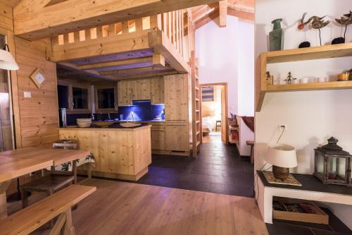 a large kitchen with wooden walls and wooden floors at Chalet Magrappe by Swiss Alps Village in Veysonnaz