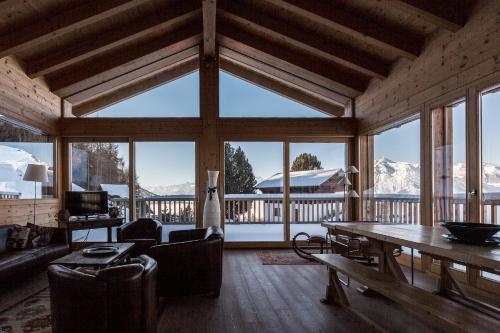 salon z widokiem na pokryte śniegiem góry w obiekcie Chalet Magrappe by Swiss Alps Village w mieście Veysonnaz