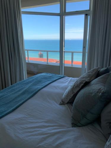 a bedroom with a bed with a view of the ocean at 702 Oyster Schelles in Durban