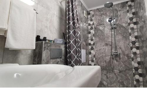 a bathroom with a white sink and a shower at K&K Stylish Elegance in Burgas City