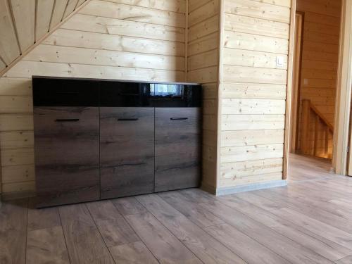 a large black cabinet in a room with wooden walls at Skrzynia 12 in Skrzynia