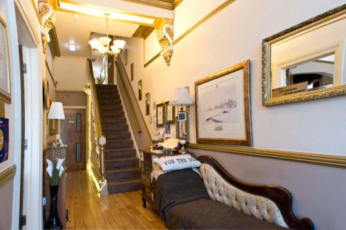 a living room with a couch and a staircase at The Leicester in Southport