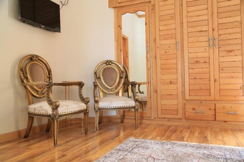 two chairs sitting in a room with a tv at ISLE OF HIGHLAND TOURS Guest House in Gilgit