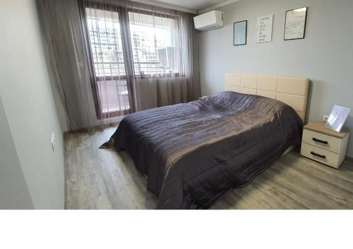 sypialnia z dużym łóżkiem i oknem w obiekcie K&K Stylish Elegance w Burgas
