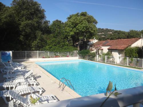 une piscine avec des chaises longues à côté dans l'établissement Residence Pezza Cardo, à Porto-Vecchio
