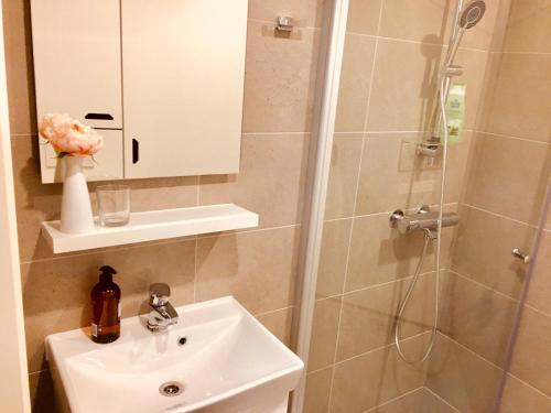 uma casa de banho com um lavatório e um chuveiro em Patria apartments em Lahti