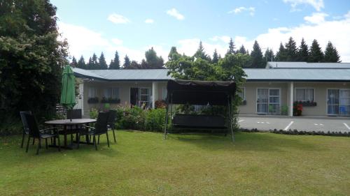 a table and chairs in the yard of a house at Aden Motel in Te Anau