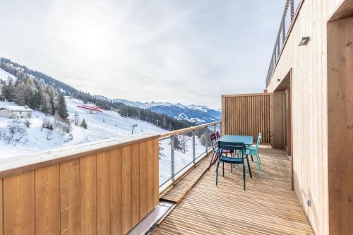 a wooden balcony with a table and chairs on it at LE RIDGE Appartement Premium - Les Arcs Paradiski in Arc 1600