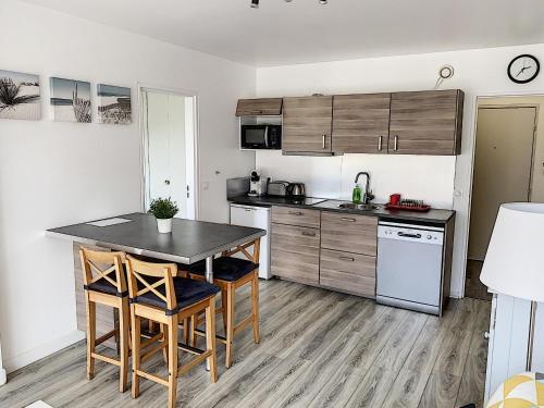 a kitchen with a table and chairs in a room at 2 PIECES CENTRE ET MER in Cabourg