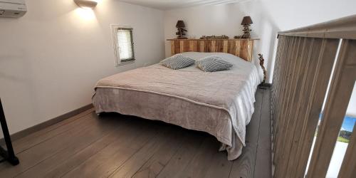 a bedroom with a large bed with a wooden headboard at Maison d'hôtes la Garenne in Puyloubier