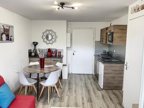 a small kitchen with a table and chairs in a room at 2 PIECES JARDIN, ACCES DIRECT MER ET PROCHE THALASSO in Cabourg