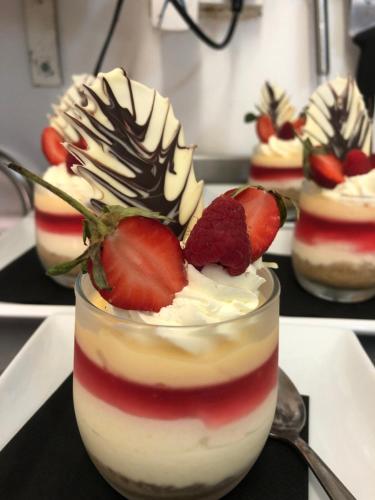 a row of desserts with whipped cream and strawberries at The Moorland Hotel in Wotter
