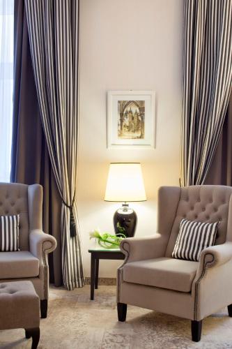 a living room with two chairs and a lamp at Metropolitan Boutique Hotel in Kraków
