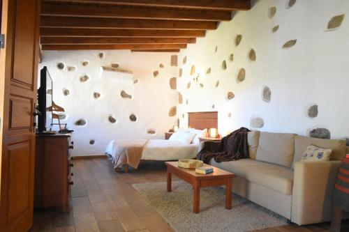 a living room with a couch and a bed at Finca Mariola - Alpendre in San Bartolomé