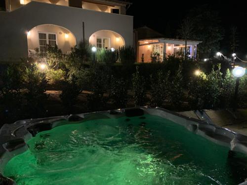 a swimming pool in front of a house at night at Relais dei Molini in Castagneto Carducci