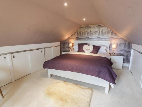 a bedroom with a large bed in a attic at Ettrick Cottage in Port Bannatyne