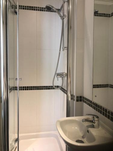 a white bathroom with a sink and a shower at The Brotherswater Inn in Patterdale