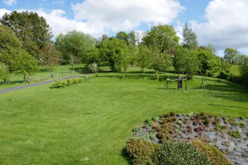 a park with green grass and trees and a road at B&B La ferme de Berwausault in Herve