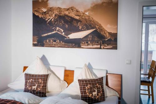 a room with two chairs and a picture of a house at Haus Erli in Mittenwald