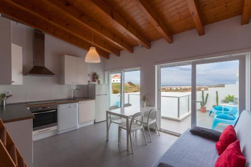a kitchen and living room with a table and chairs at Sea View Apartment Carrapateira in Carrapateira