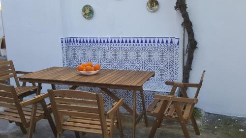 GRAN CASA RURAL CON PATIO EN ENCINAREJO DE CÓRDOBA في Encinarejo De Córdoba: طاولة عليها كراسي وصحن من البرتقال