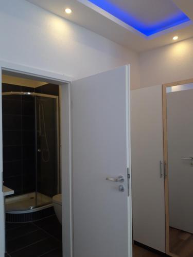 a bathroom with a toilet and a blue ceiling at Trang Hotel-Restaurant in Rastatt