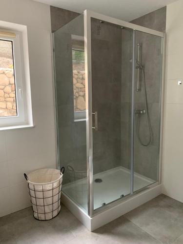 a glass shower stall in a bathroom with a window at Wakacyjny Hartowiec 2 in Grodziczno