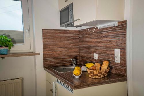 a kitchen counter with a sink and a basket of bread at Haus Erli in Mittenwald