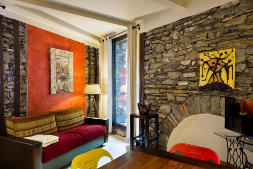 a living room with a couch and a stone wall at Agriturismo l'Adagio in Badalucco