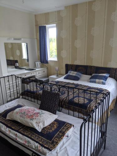 Balmoral Lodge Hotel في ساوثبورت: غرفة نوم بسريرين ومطبخ